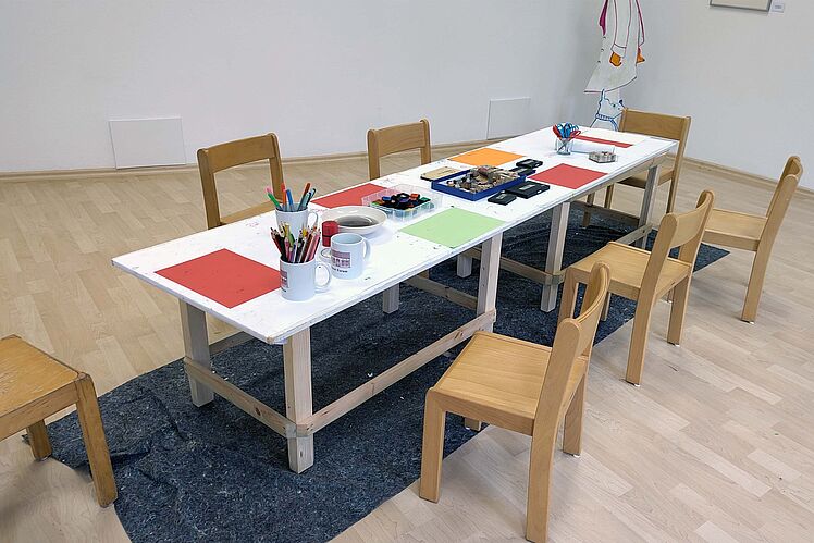 Der selbst gebaute Tisch auf Kinderhöhe mit Bastelmaterialien in der Galerie
