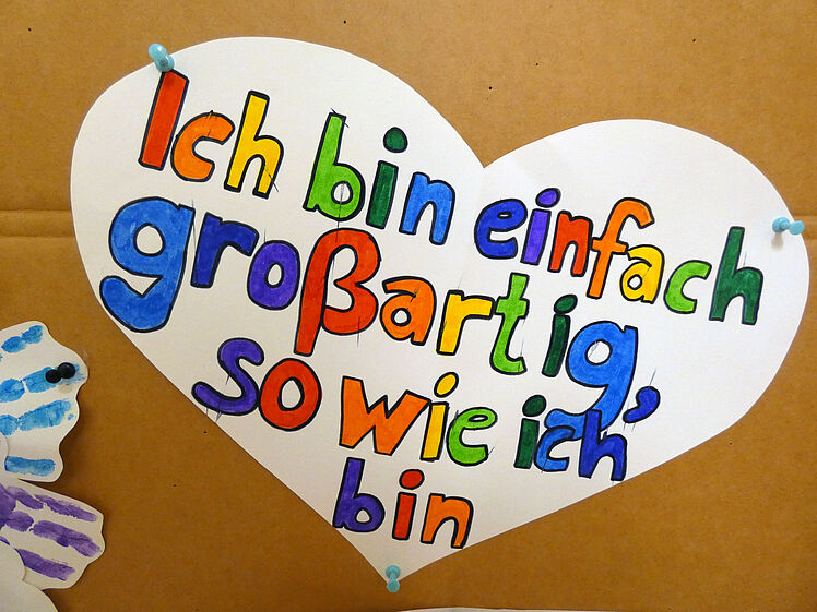 weißes Herz mit der bunten Aufschrift "Ich bin einfach großartig, so wie ich bin"