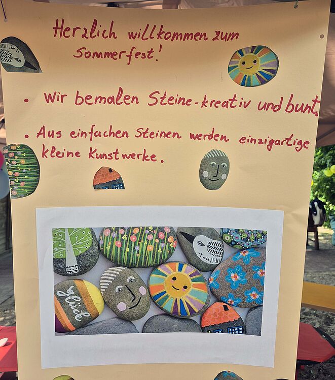 Plakat mit der Aufschrift "Herlich willkommen zum Sommerfest" und der Ankündung zur Aktion "Steine bemalen"