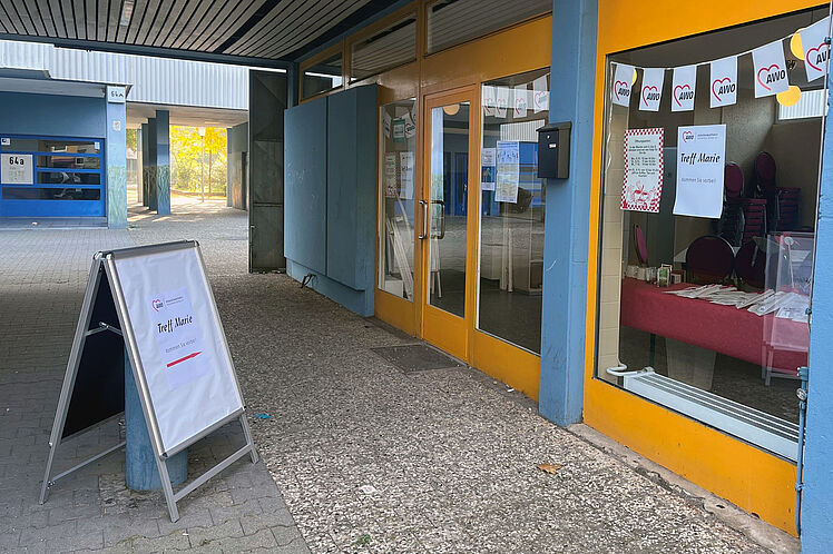 Eingangsbereich des Treff Marie mit AWO-Wimpeln im Fesnter
