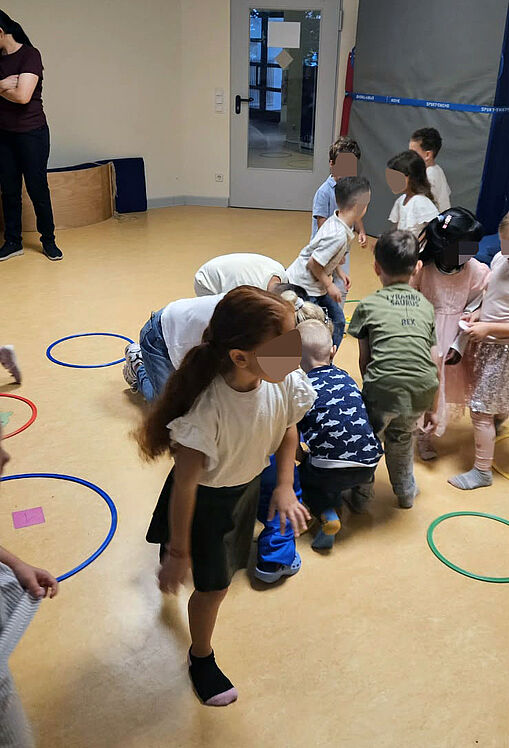 Kinder spielen und tanzen im Sportraum
