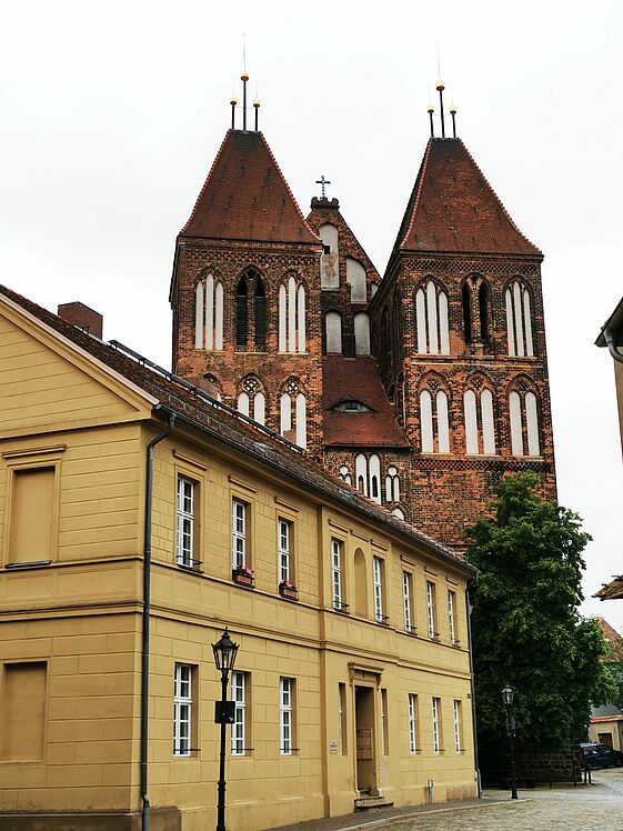 Türme der Kirche St. Nikolai, im Vordergrund ein Altstadthaus