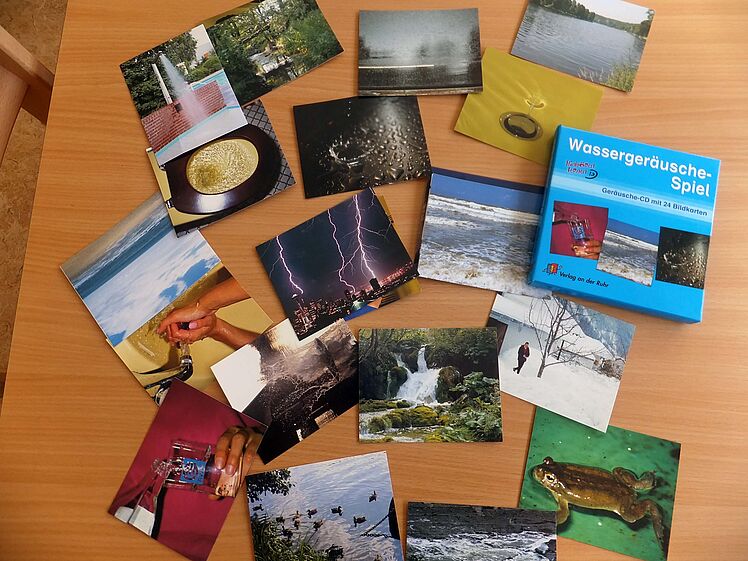 Fotos von verschiedenen "Wassersituatione" wie Wasserfall, See, Duschbrause etc. und die Box des "Wassergeräusche-Spiels"