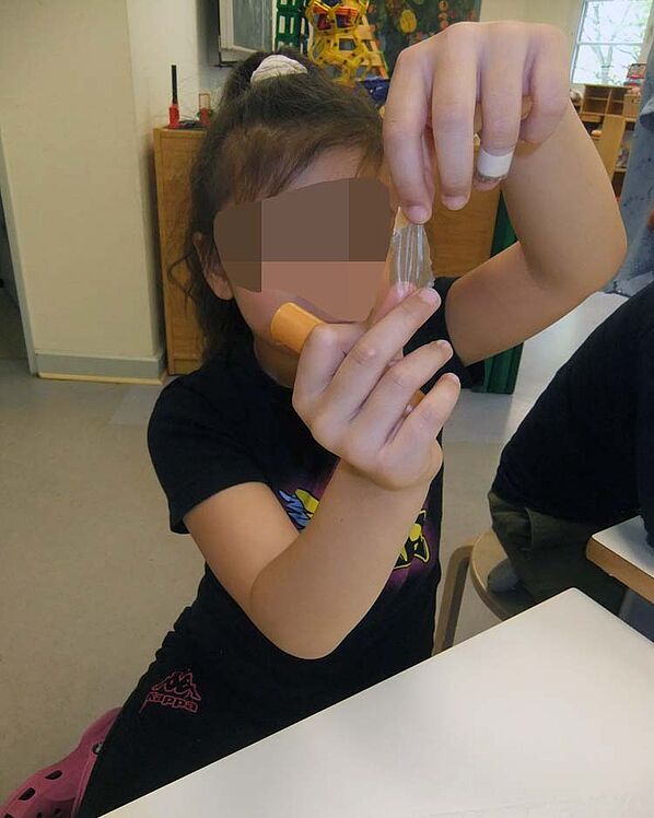 Kind betrachtet Wurst und abgezogene Pelle