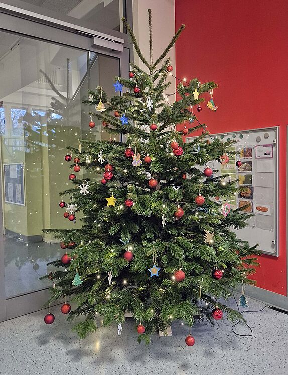 großer geschmückter Weihnachtsbaum im inneren Eingangsbereich der Kita