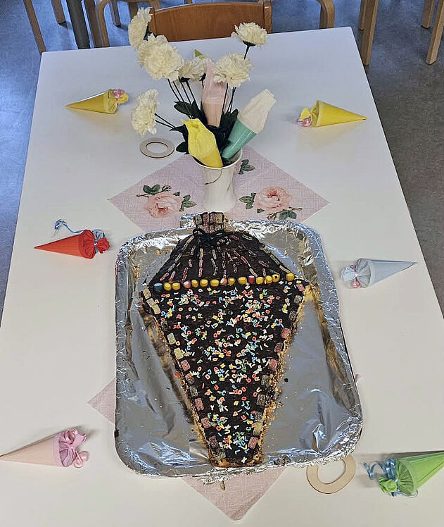 Kuchen in Form einer Zuckertüte auf dem geschmückten Tisch