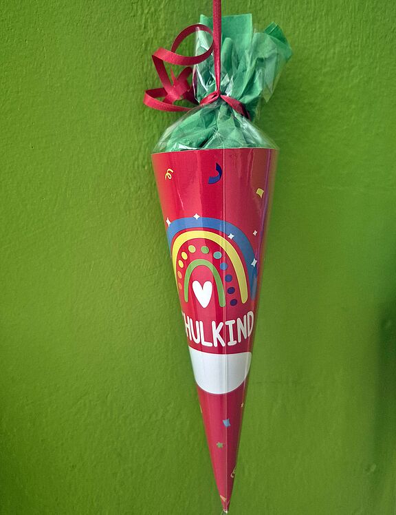 Rote Schultüte vor gründer Wand