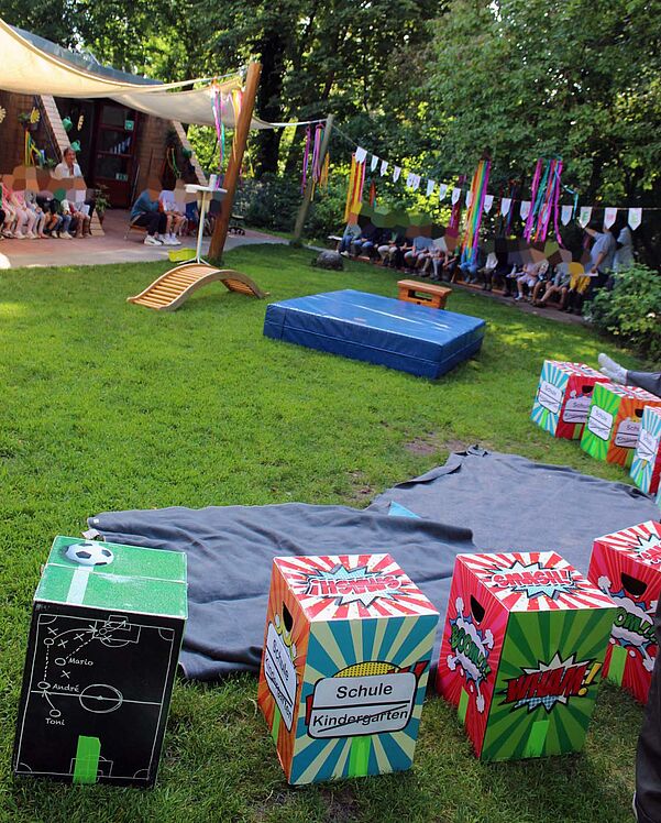 Außenbereich der Kita beim Wechsel- bzw. Abschlussfest mit einer kleinen Turnbrücke, über die die Kinder symbolisch in den neuen Lebensabschnitt eintreten.