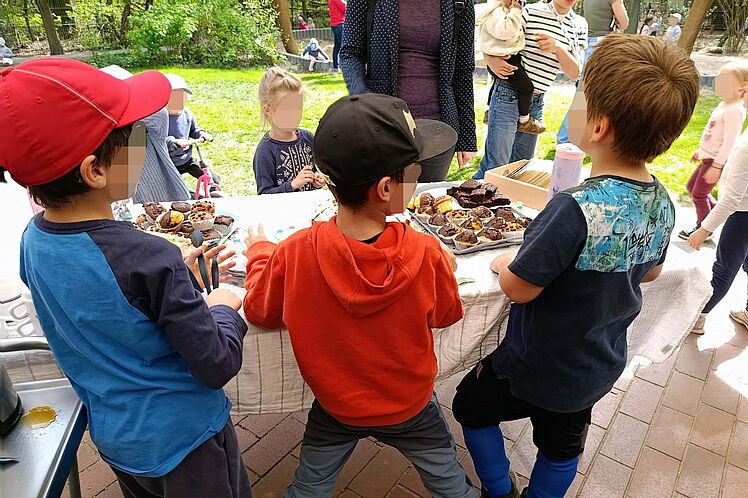 Kinder stehen um den Tisch mit ihrem Selbstgebackenem