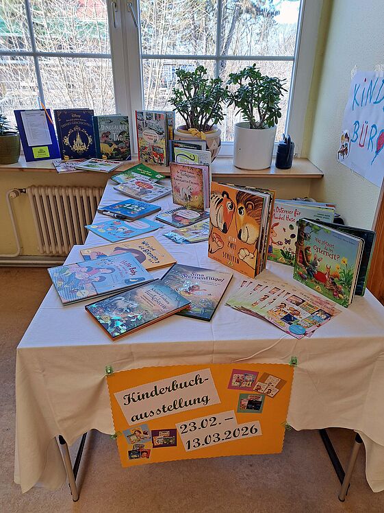 Aufnahme Büchertisch hochkant, Plakat mit Ausstellungsdauer ist sichtbar