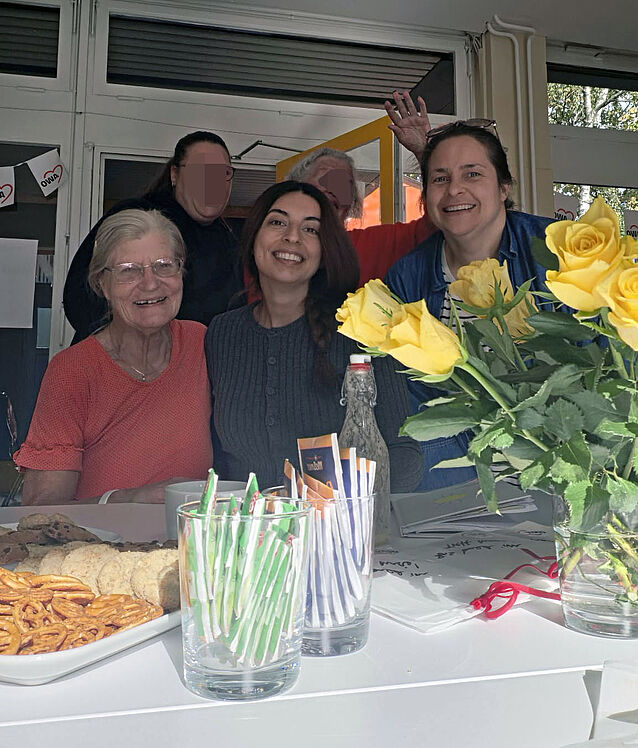 Ursula Bach-Mielke vom Stützpunkt Staaken mit den Projektkoordinatorinnen und zwei weiteren Frauen im Innenraum am Tisch mit Keksen, Tee und Kaffee