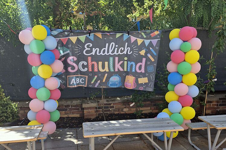 Mit bunten Ballons geschmücktes Plakat mit der Aufschrift "Endlich Schulkind!"