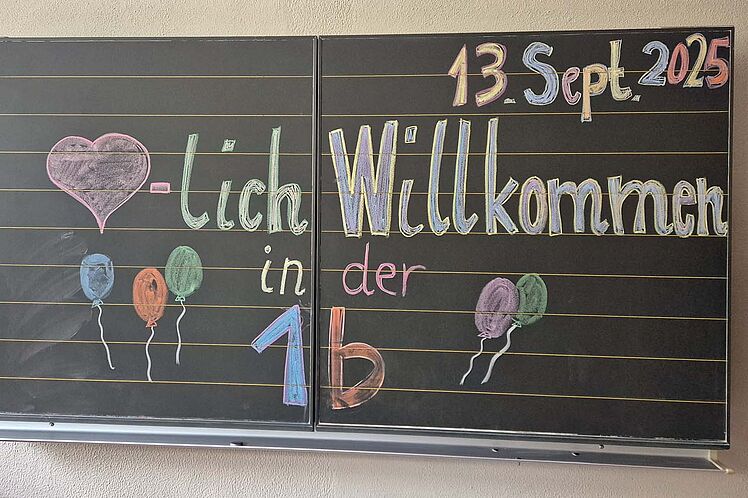 Willkommensgruß an die Erstklässler*innen auf einer Tafel