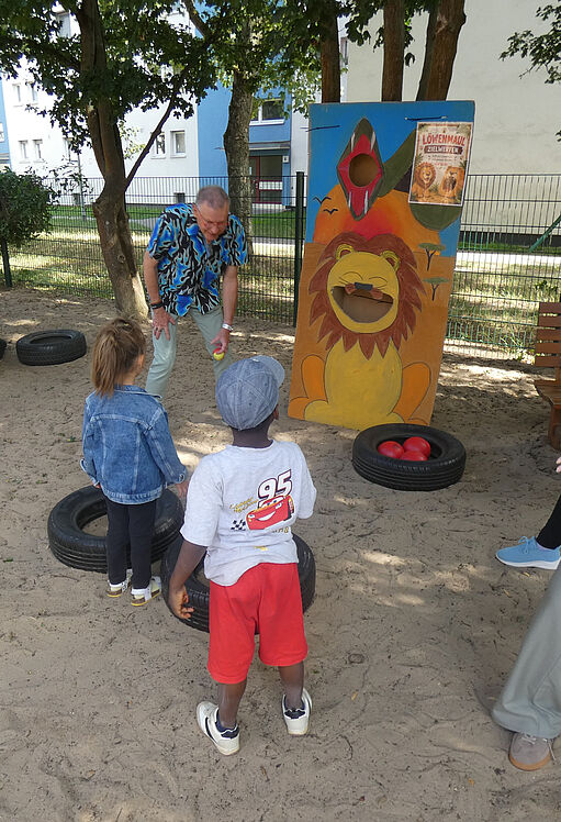 Kinder und Erzieher beim Wurfspiel