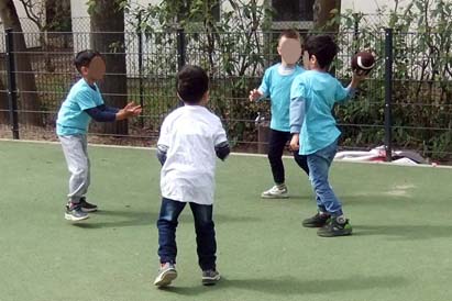 Kinder mit dem Football auf dem Sportplatz